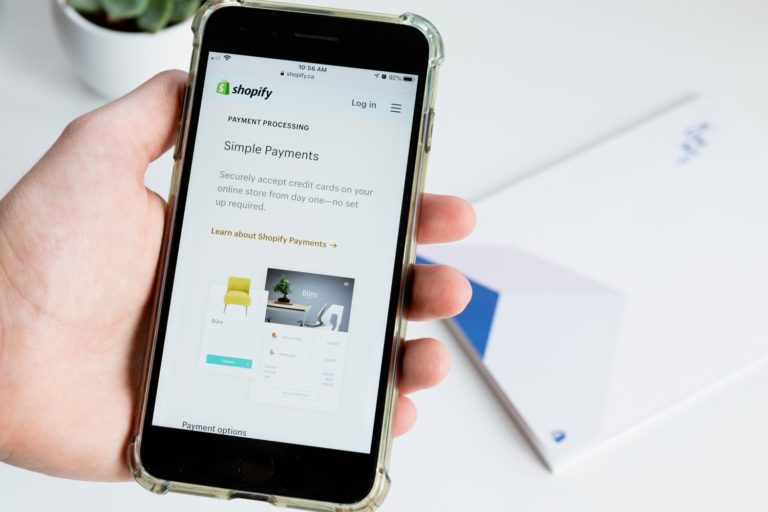 Mit Handy Informationen zu Shopify Payments recherchiert